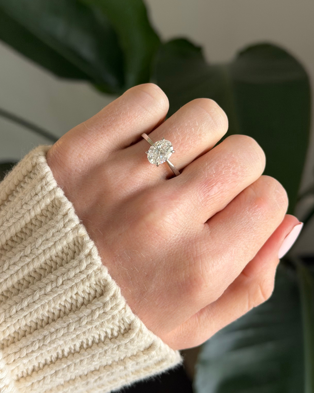 Oval solitaire engagement ring worn on hand