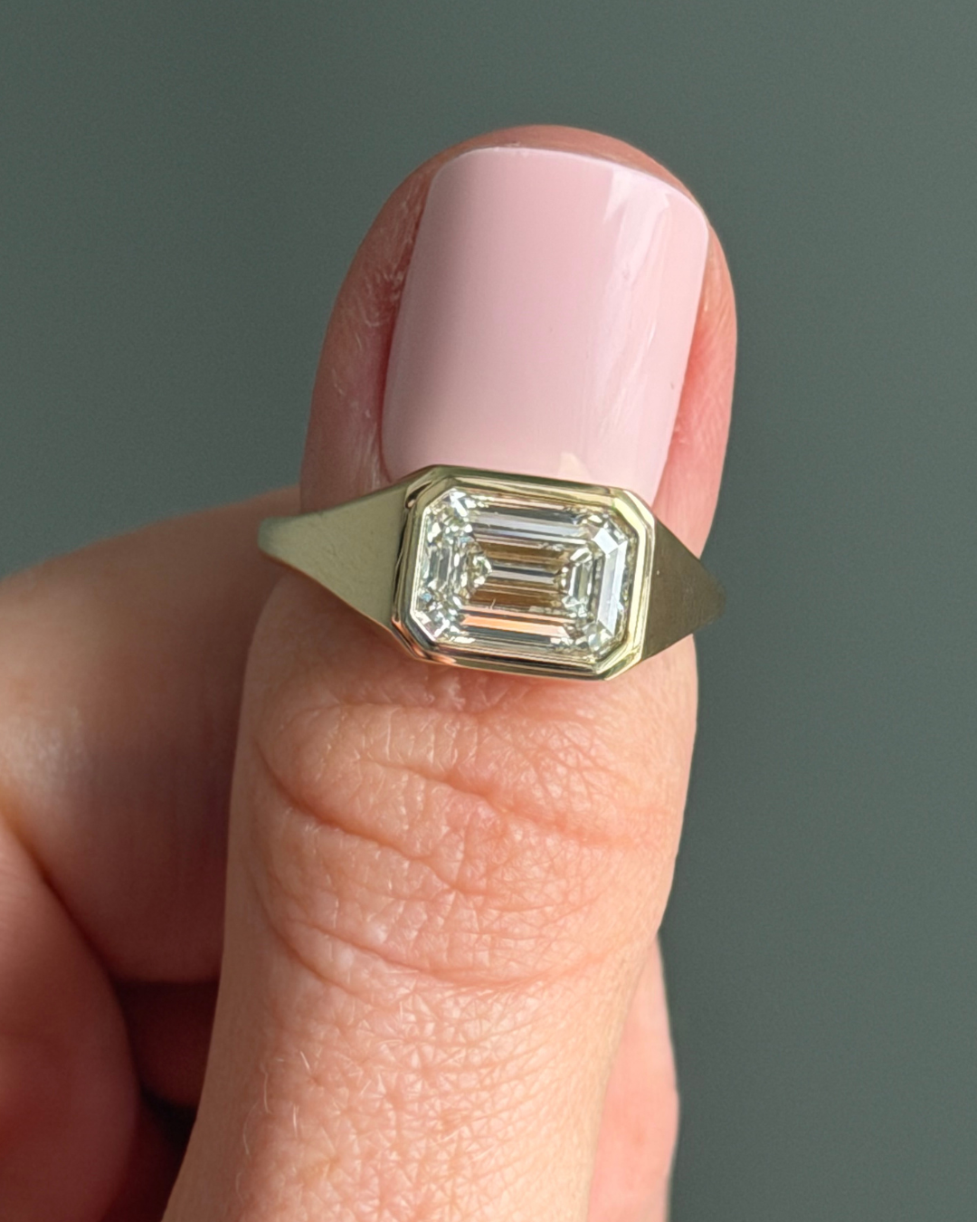 Emerald cut bezel signet style ring in yellow gold