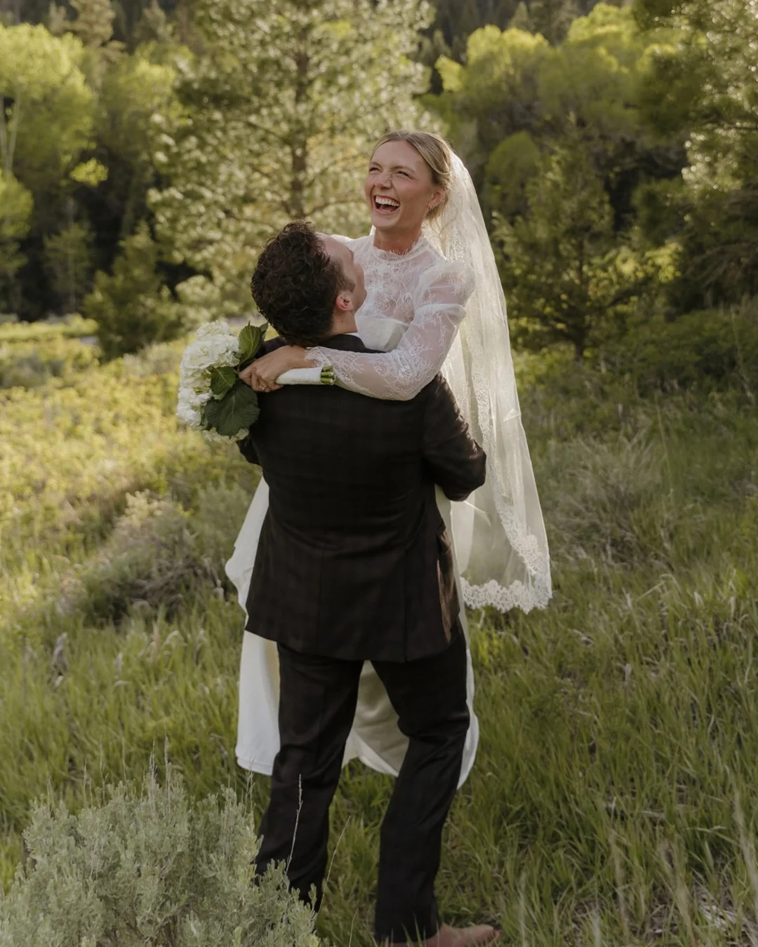 Bride and groom laughing together outdoors
